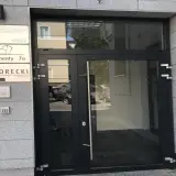 Wejście do budynku z tabliczkami: Kancelaria Radców Prawnych, Apartamenty 7a, Kancelaria Doradcy Finansowego SKORECKI.